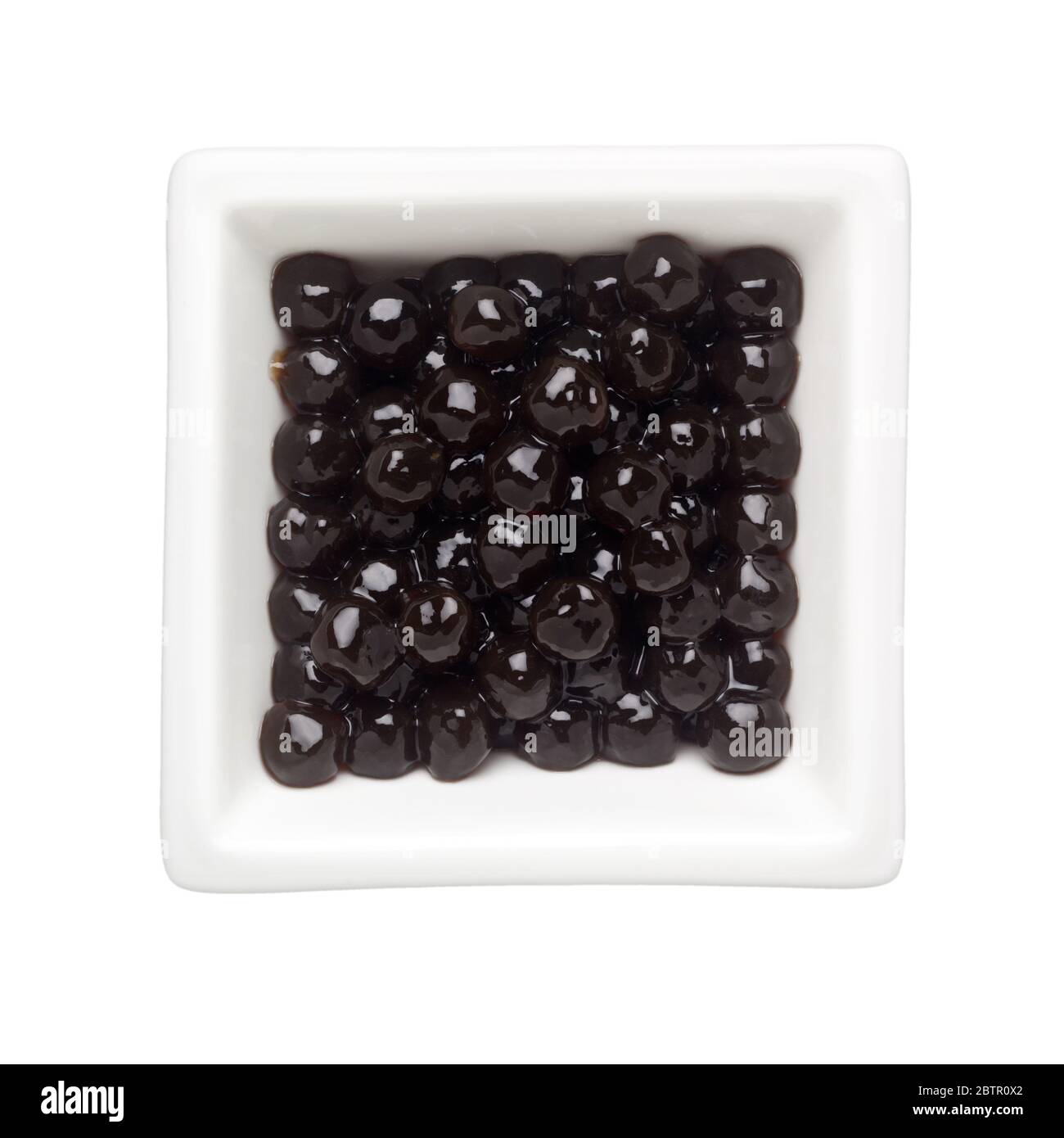 Schwarze Tapioka Perlen in einer quadratischen Schale auf weißem Hintergrund isoliert Stockfoto
