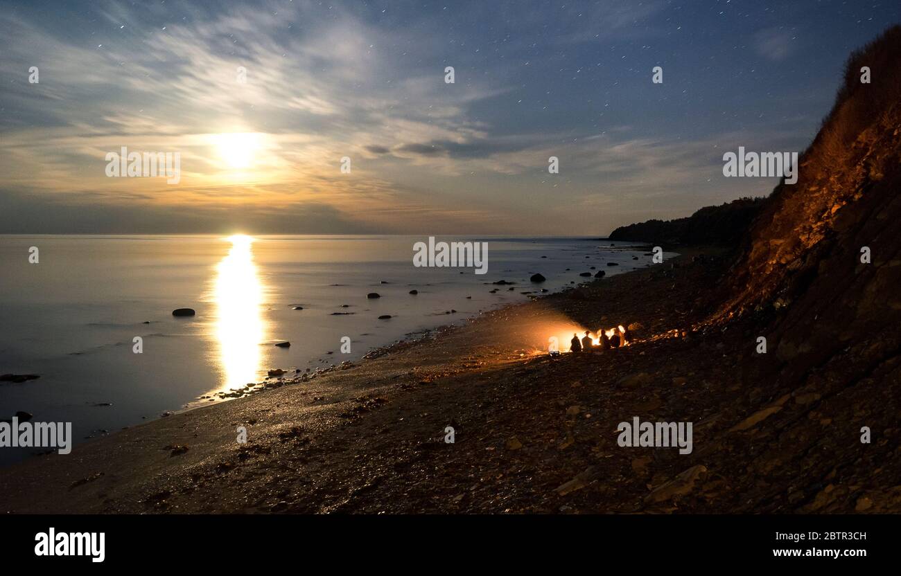 Lagerfeuer auf den Strängen mit Mond beleuchteten Himmel. Stockfoto