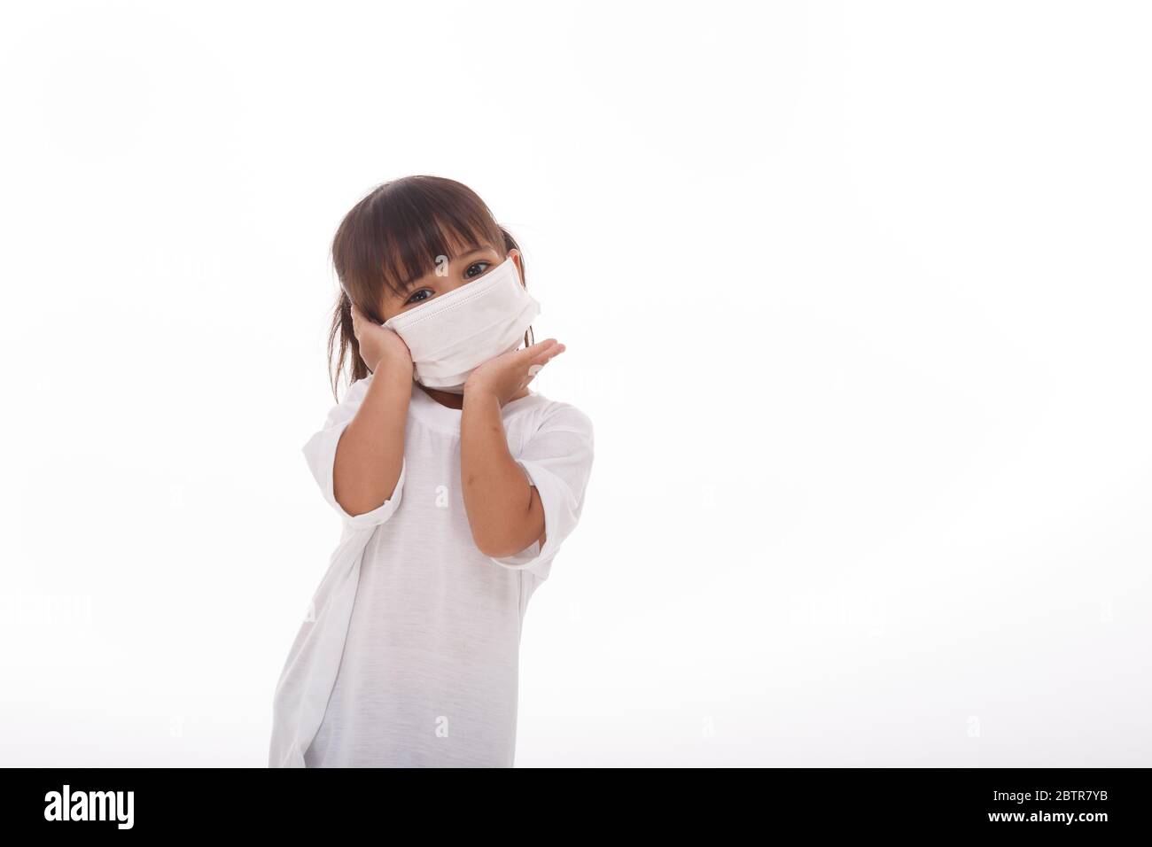 Glücklich asiatische Mädchen tragen hygienische Maske, um Infektion Corona Virus zu verhindern Luftverschmutzung pm2.5.auf weißem Hintergrund Stockfoto
