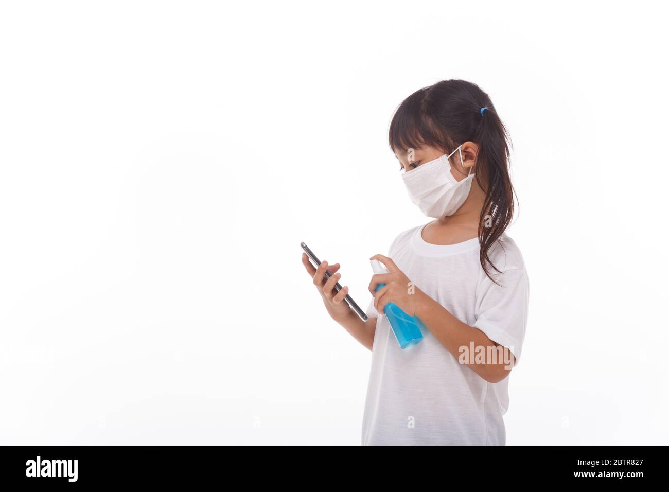 Asiatische Mädchen tragen Maske Reinigung Smartphone-Bildschirm mit Alkohol.auf weißem Hintergrund. Konzept der Reinigung schmutzigen Bildschirm Telefon für die Prävention von Krankheiten von b Stockfoto