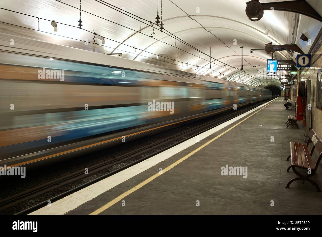 Museum Bahnhof in Sydney, Australien, Plattform mit Bänken für das Warten auf den Zug, Zug läuft durch verschwommen in Bewegung Stockfoto