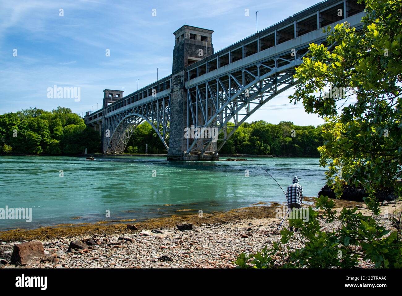 Angeln an der Anglesey-Küste der Menai Strait mit Blick auf die Britannia Bridge in North Wales Stockfoto