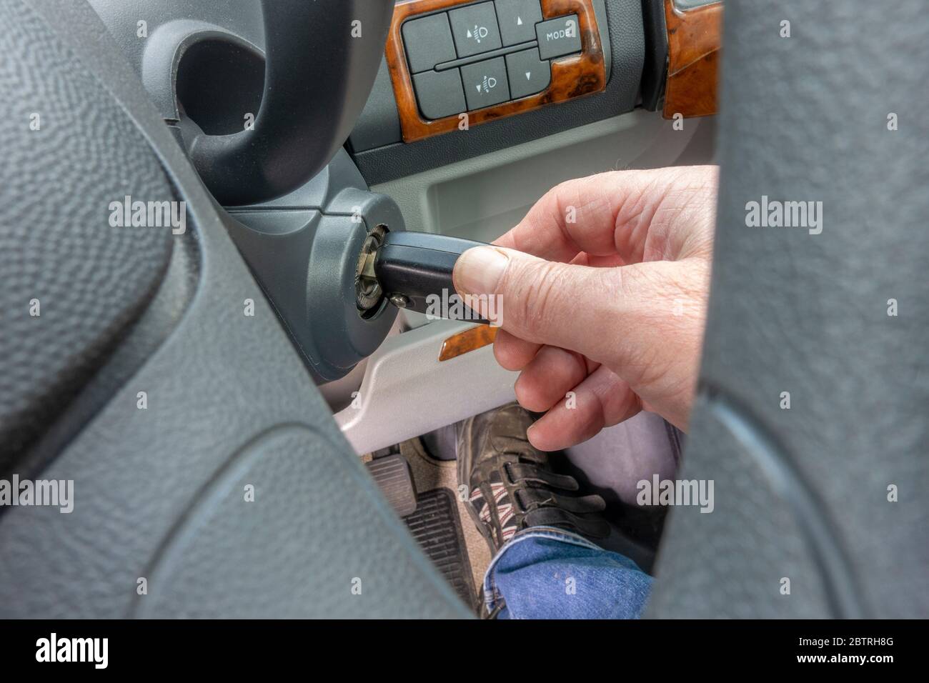 Nahaufnahme POV schoss durch das Lenkrad eines Fahrzeugs, auf die Hand  eines Mannes, der den Schlüssel in der Zündung drehte, mit dem Fuß auf dem  Gaspedal Stockfotografie - Alamy