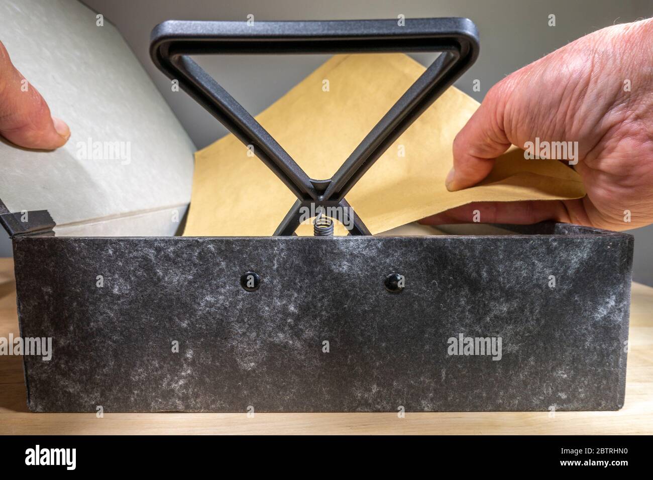 Ein Mann die Hand mit einem Kasten Datei Deckel öffnen und Feder Halter angehoben, ersetzen oder herausnehmen ein Dokument. Stockfoto