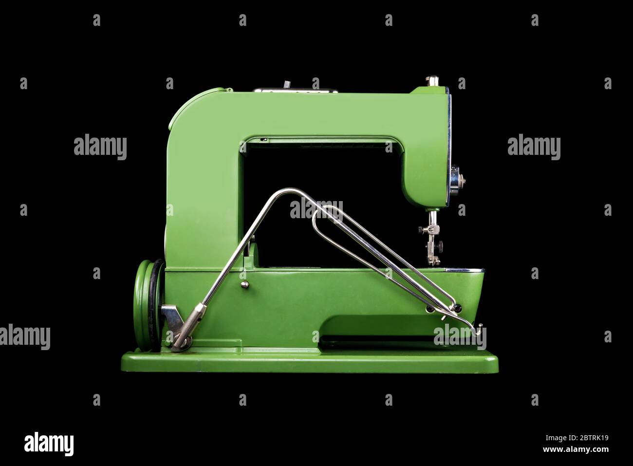 Seitenansicht einer alten Vintage-grünen Nähmaschine auf schwarzem Hintergrund Stockfoto