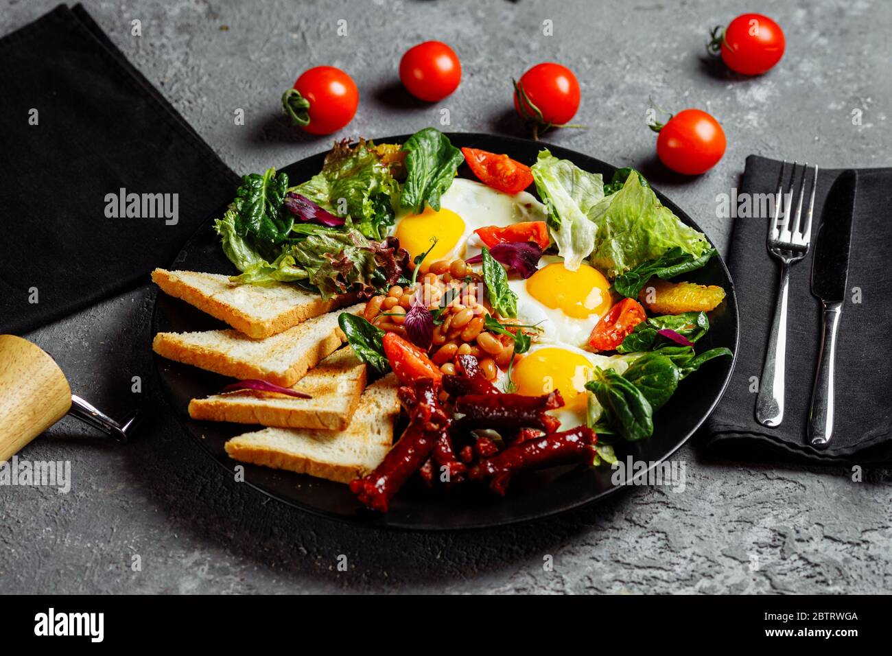 Tolles Frühstück mit Spiegeleiern, Toast, Salat und Tomaten. Fotografiert in der Nähe Stockfoto