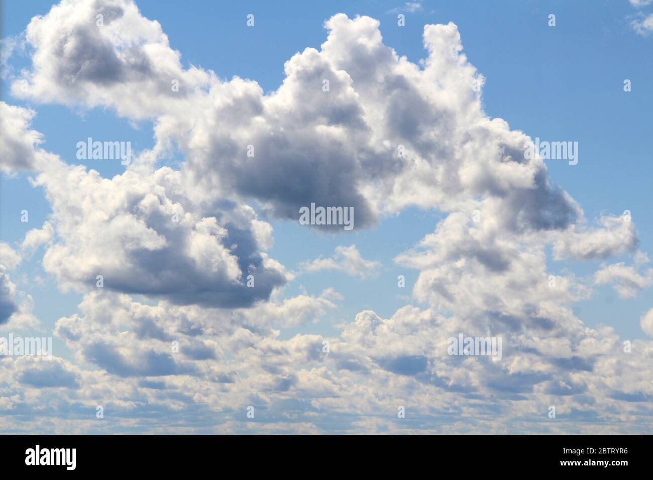 Weiße flauschige Wolken auf einem Hintergrund von blauem Himmel im Sommer. Das Konzept von Wetter und Klima. Stockfoto