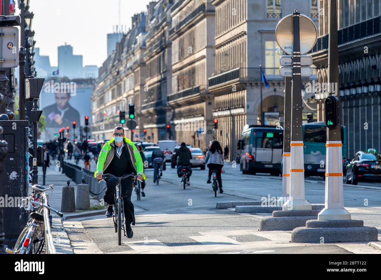 Paris, Frankreich - 14. Mai 2020: Mann auf seinem Fahrrad mit einer chirurgischen Maske, um sich vor Covid-19 in einer Straße in Paris zu schützen Stockfoto