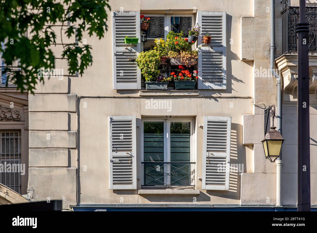 Paris, Frankreich - 14. Mai 2020: Fenster mit Blumen in einem pariser Haus Stockfoto