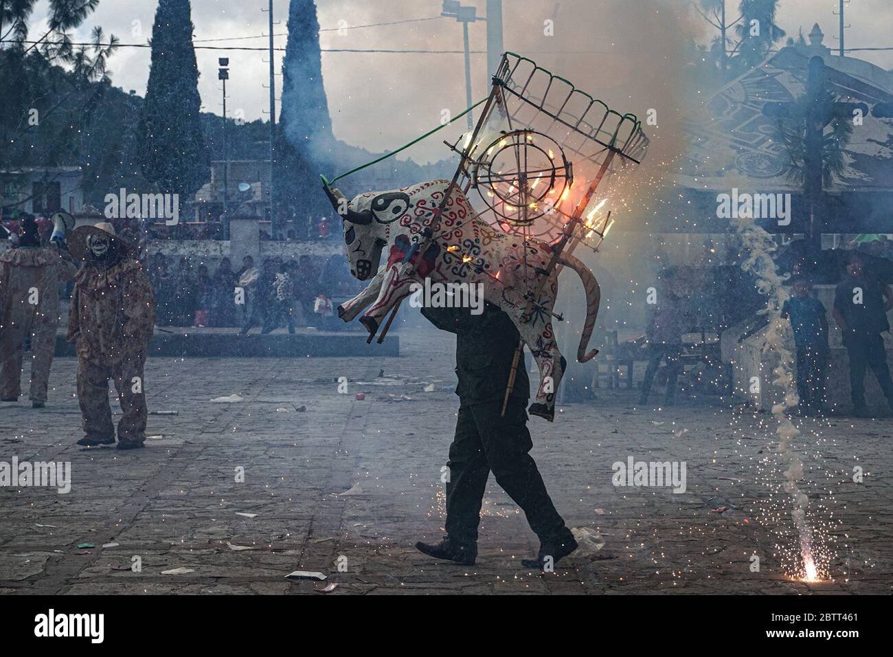 Menschen, die zu Ehren des Schutzheiligen lorenzo Mártir ein Fest feiern, tragen in Zinacantán, Mexiko, Feuerwerkstiere auf ihren Schultern. Die Stiere sind aus Stroh und mit Papier und anderen Materialien mit Feuerwerk innen gefüllt bedeckt. Sie werden nach der Segnung in der Kirche, zur Aufregung aller Zuschauer, die sich versammeln, um zu beobachten, angezündet. (Marissa Revilla, GPJ Mexiko) Stockfoto