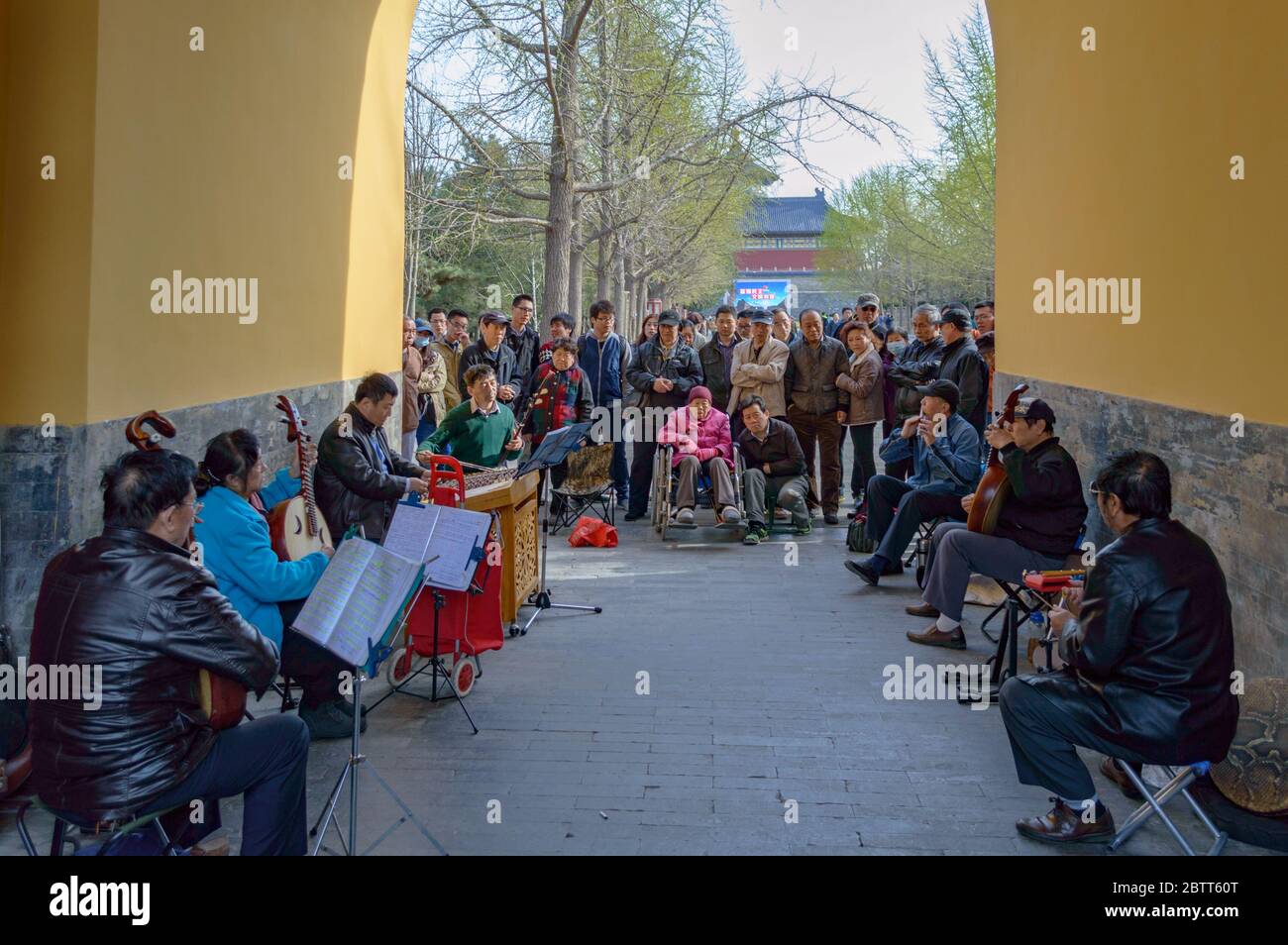 Peking / China - 5. April 2015: Eine Gruppe älterer Menschen spielt traditionelle chinesische Musik, umgeben von neugierigen Zuschauern, im Himmelstempel P Stockfoto