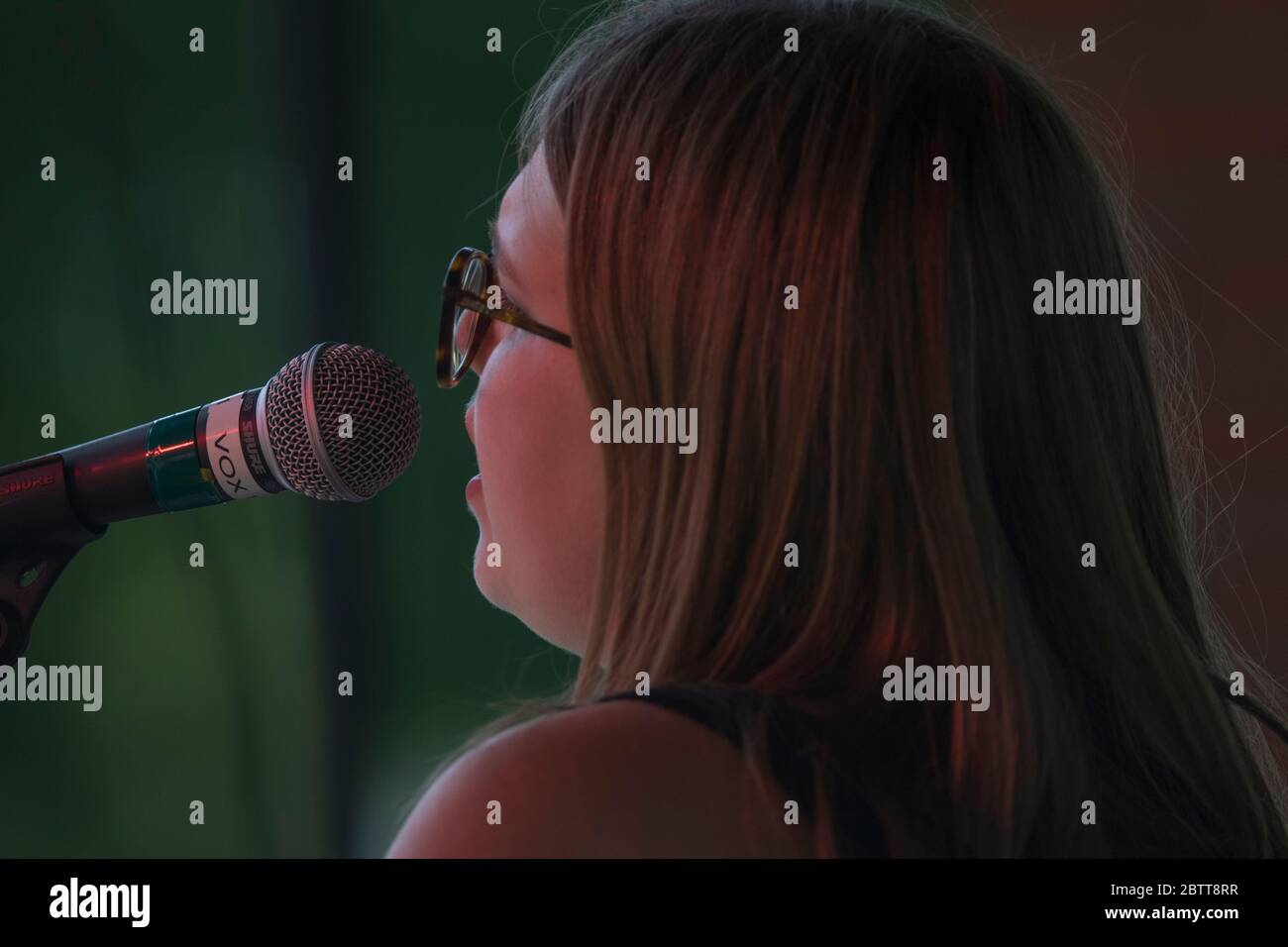 Attraktive Frau, im Outdoor-Konzert, singen und Gitarre spielen. Stockfoto