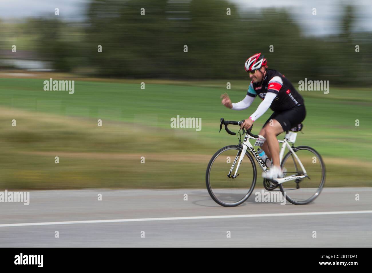 Scenic Bike Race, Einzelfahrer, in voller Rennausrüstung und Uniform. Unscharfer Hintergrund. Stockfoto