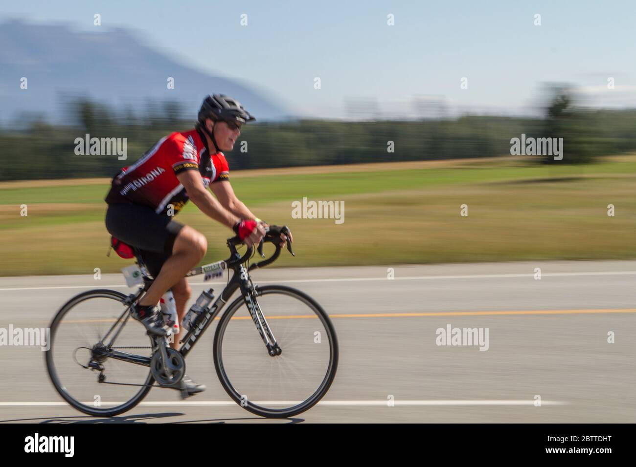 Scenic Bike Race, Einzelfahrer, in voller Rennausrüstung und Uniform. Unscharfer Hintergrund. Stockfoto