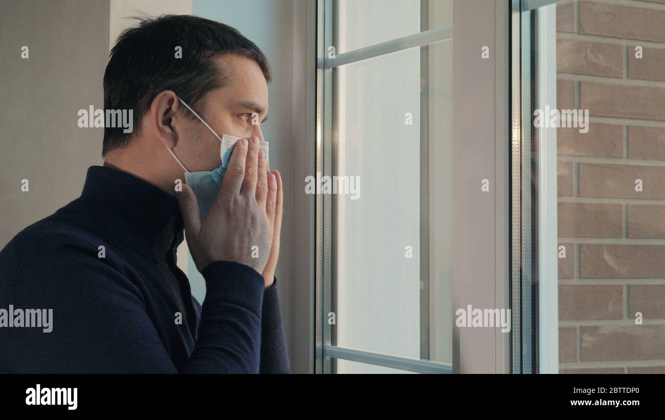 Mann setzt auf medizinische chirurgische Maske vor dem Ausgehen Stockfoto