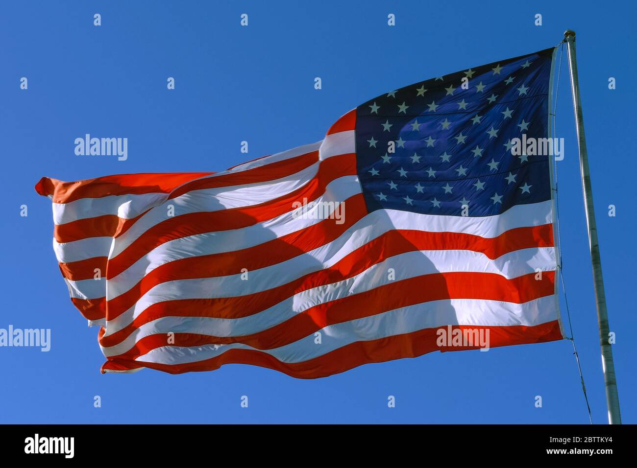 Amerikanische USA-Flagge auf einem Fahnenmast winkend im Wind Stockfoto