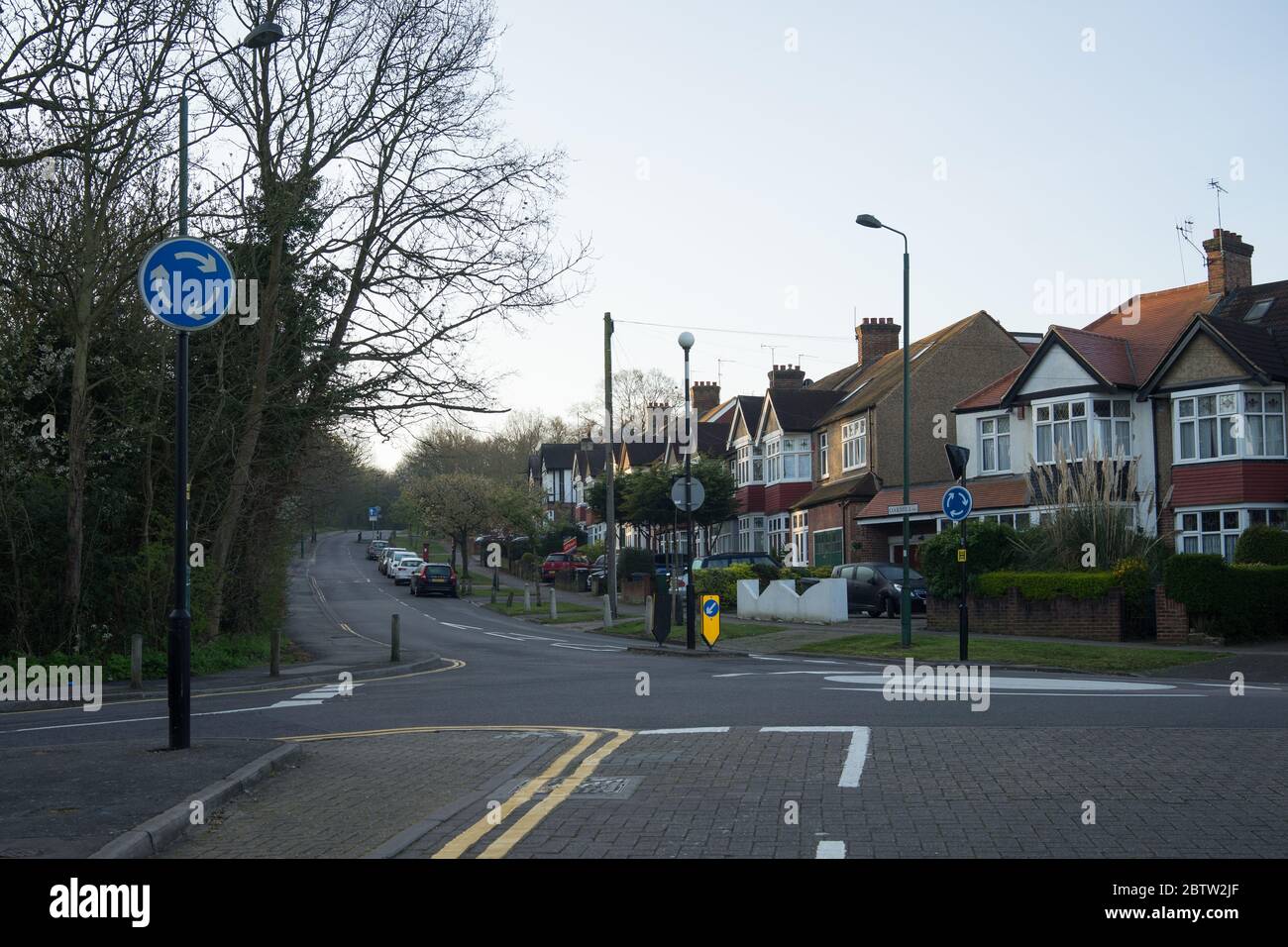 Mini-Kreisverkehr mit leerer Straße bergauf. Oak Hill, Woodford Green. Essex Stockfoto