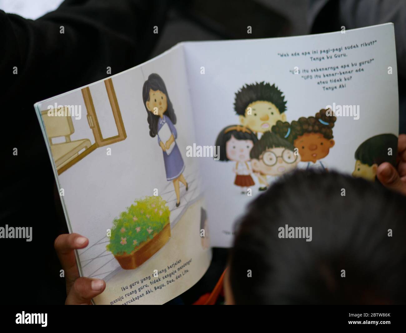 27. Jan 2020 - Tarakan/Indonesien: Feuern Sie Flüchtlingskinder, die am Nachmittag in Tarakan, Indonesien, Bücher lesen lernen. Eine Serie Stockfoto