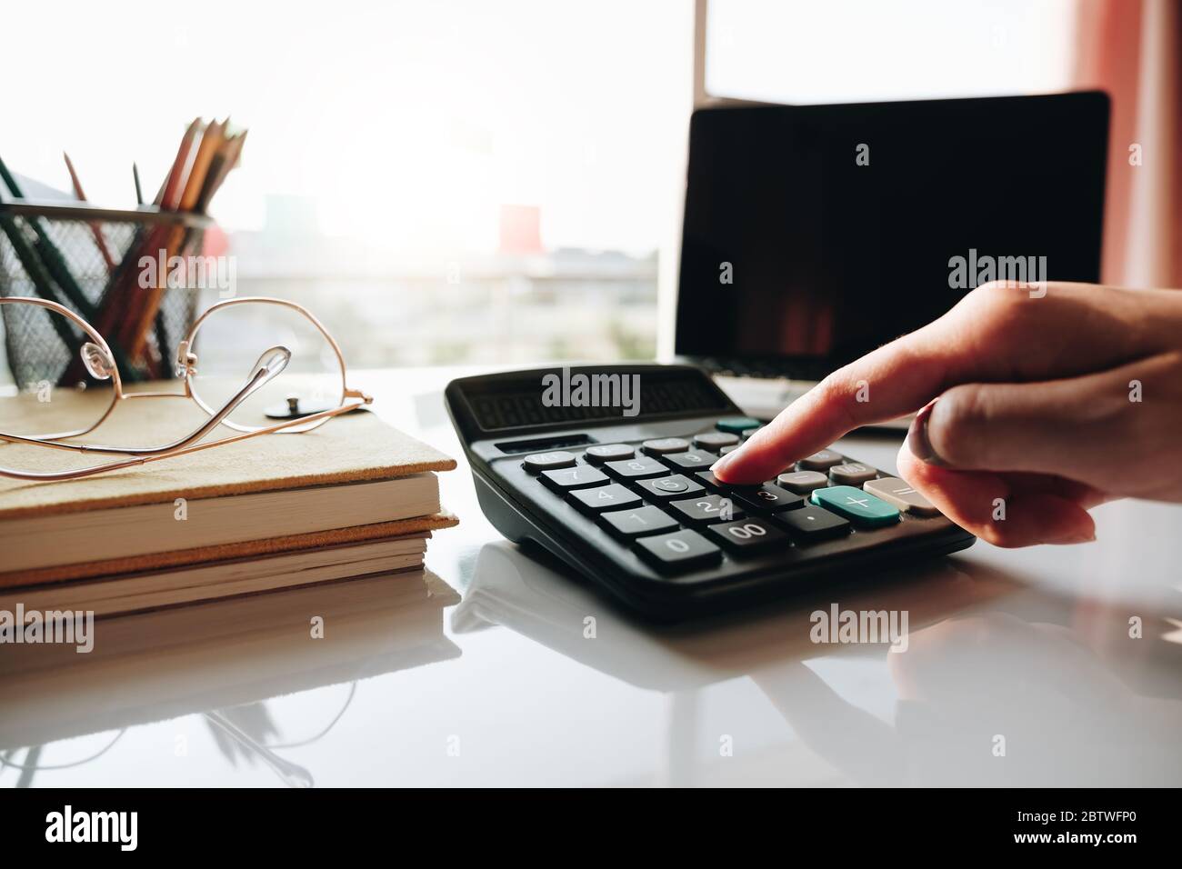 Close up Geschäftsfrau mit Rechner und Laptop für tun Mathematik Finanzen auf Holzschreibtisch im Büro Stockfoto