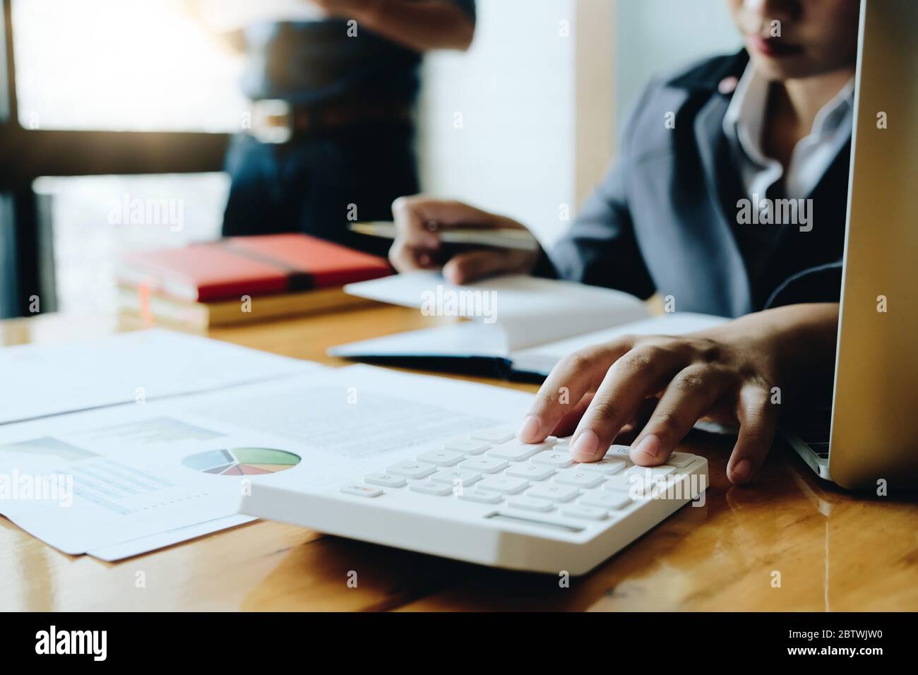 Geschäftsfrau mit Rechner für tun Mathematik Finanzen auf Holzschreibtisch im Büro Stockfoto