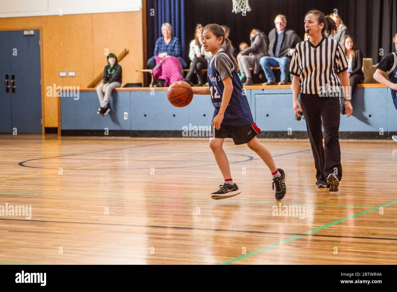 Gemischte Basketball-Aktion von Jungen und Mädchen 8 bis 10 Jahre alt, in einem Spiel. Stockfoto
