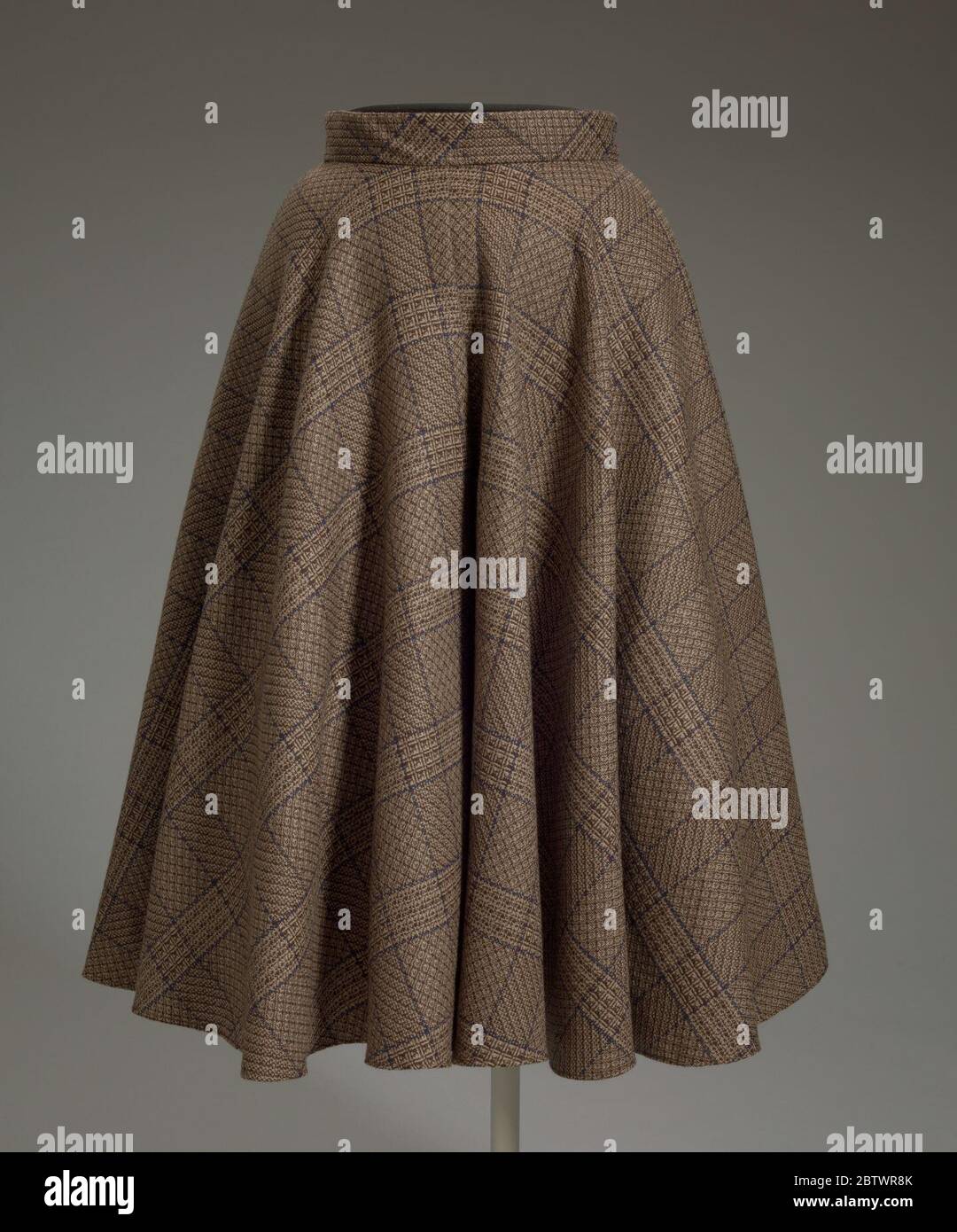 Culottes von Arthur McGee entworfen. Culottes von Arthur McGee entworfen, auch als Split Rock, palazzo Hose oder Midi Hose bezeichnet. Die Hose ist ein 4-Panel-Design aus einem mehrgewebten braunen und blauen karierten Wollstoff. Die Beine der Hose sind sehr breit und bilden einen vollen Halbkreis, wenn sie flach gelegt werden. Stockfoto