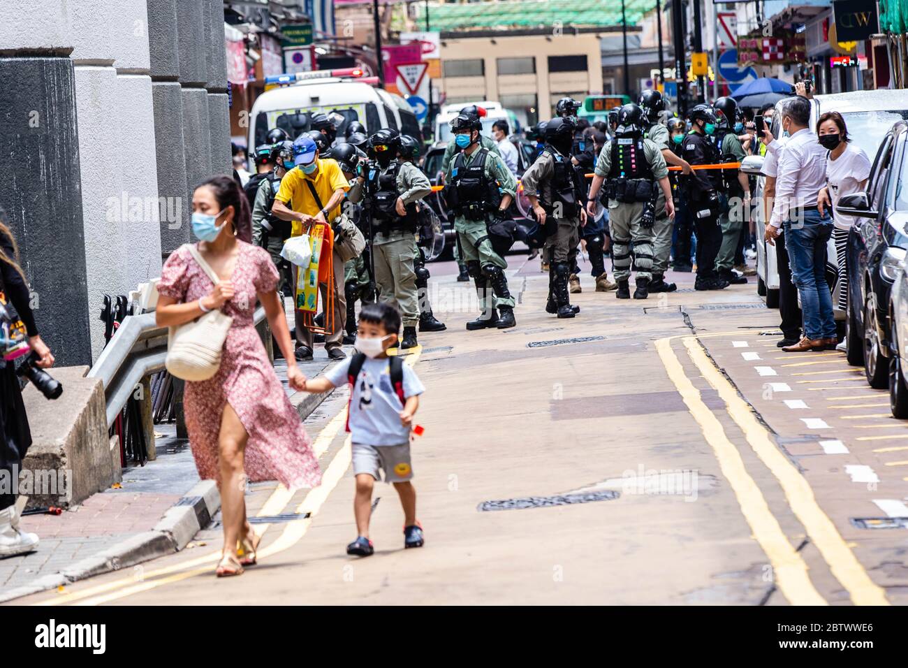 Hongkong, China. Mai 2020. Eine Frau führt ihr Kind während der Demonstration von der Bereitschaftspolizei weg.als sie gegen ein Gesetz protestierte, das die Beleidigung der chinesischen Nationalhymne kriminalisieren würde, marschierten Demonstranten auf den Straßen und skandierten Lieder und Parolen. Später tauchte die Polizei in Bereitschaftspolizei auf und feuerte Pfefferspray ab, um mehrere Demonstranten zu verhaften. Quelle: SOPA Images Limited/Alamy Live News Stockfoto