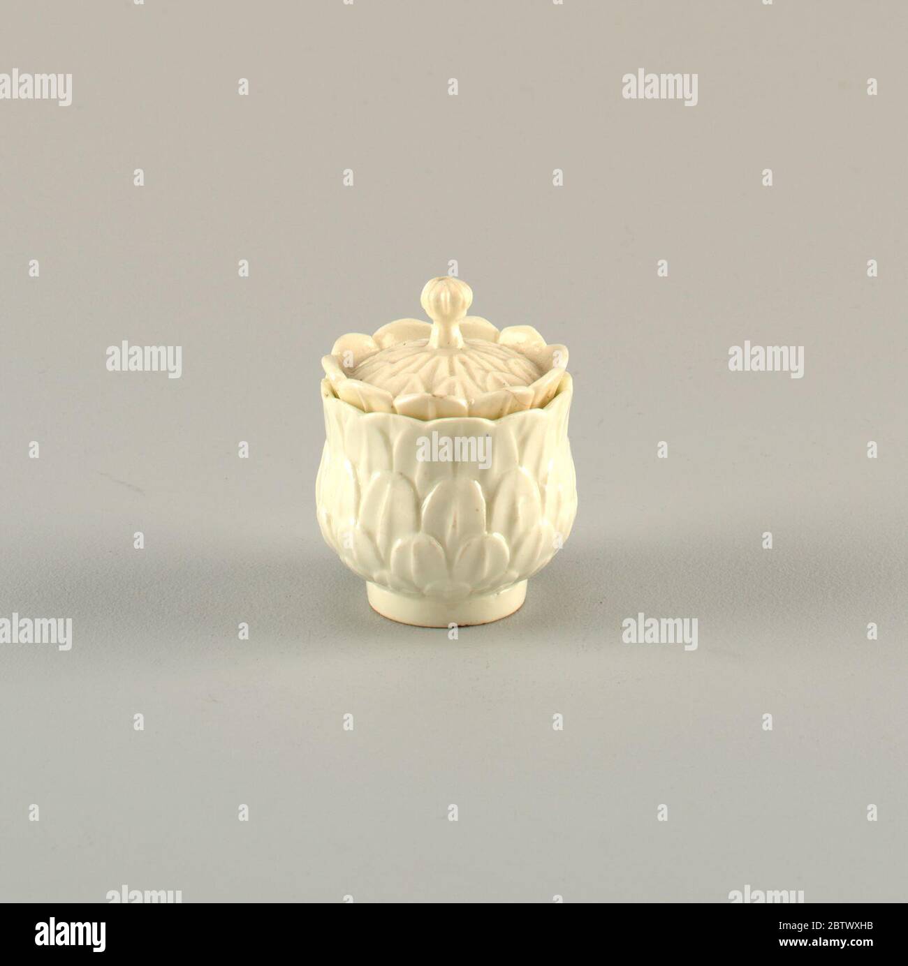 Covered Cup mit abgeformten Artichoke-Blättern. Forschung in ProgressAuf dem einfachen Fuß, eine umgekehrte glockenförmige Tasse; die Außenseite mit Relief-Schnitt Artischockenblätter bedeckt, bilden scalloped Rand über inneren Rand. Cover mit leichten Kuppel, bedeckt mit Relief-Schnitt Artischocke Blätter, und eine Reihe von stehenden Blättern um den Rand. Stockfoto