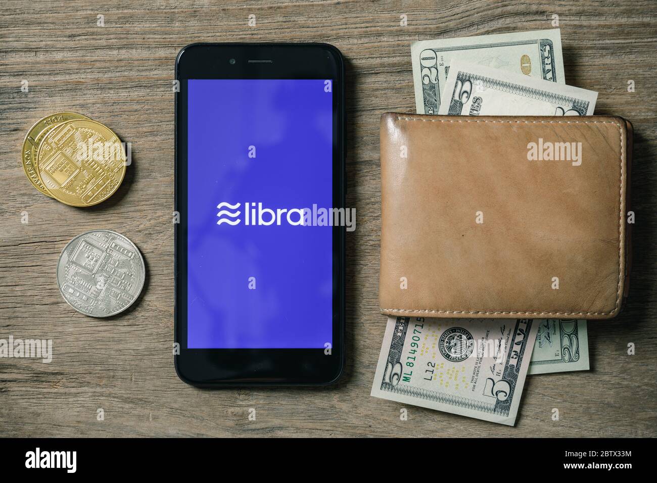 Chiangmai, Thailand - 27. Juni 2019: Smartphone mit Libra-Logo auf dem Bildschirm und digitale Goldmünzen von Kryptowährung, Facebook kündigt Libra Kryp an Stockfoto