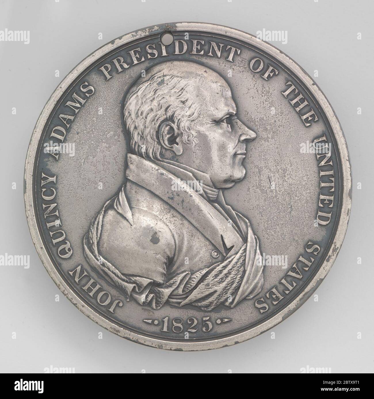 John Quincy Adams. Die Rückseite dieser Medaille ist ähnlich denen, die für die Präsidenten von Thomas Jefferson bis Zachary Taylor geschaffen wurden: Zwei gefalzte Hände – Euro-Amerikaner (mit Uniform) und Inder (mit gekreuzten Pfeifen und Tomahawk) – und die Worte „FRIEDEN UND FREUNDSCHAFT“. El reverso de esta med Stockfoto