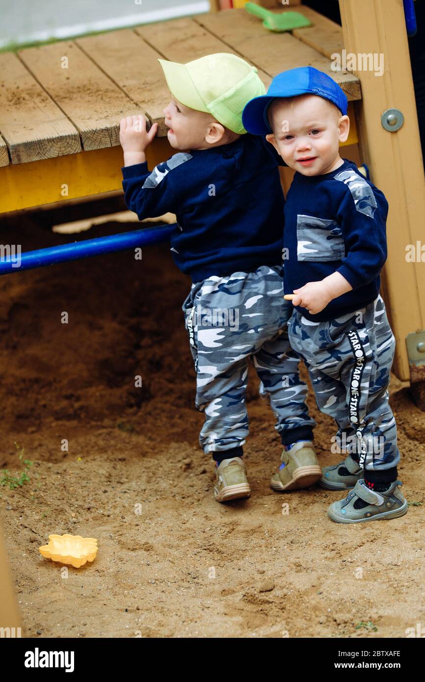 2 Zwillingsbrüder spielen zusammen auf dem Spielplatz, 1-2 Jahre alt Stockfoto