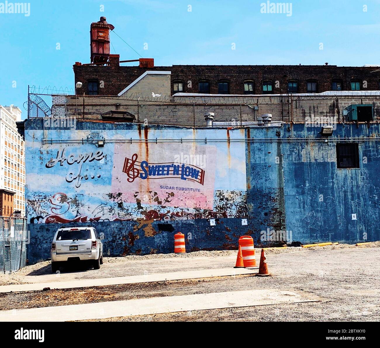 Parken des Autos vor einer Hauswand mit zerbröckelndem Werbebild, Brooklyn, New York City, USA Stockfoto