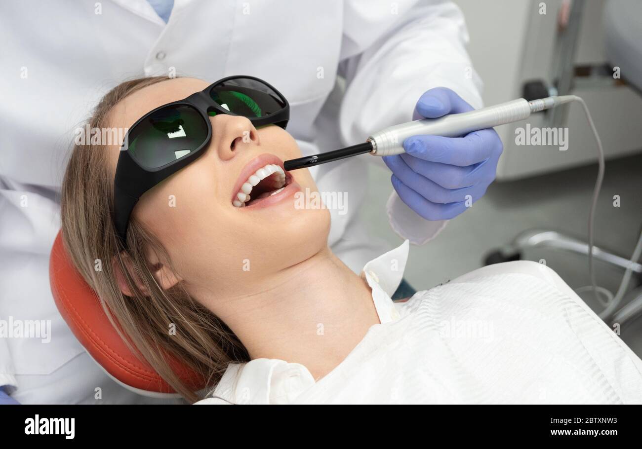 Mit einer modernen Methode der Laser-Zahnbehandlung. Zahnpflege, perfektes Lächeln Stockfoto