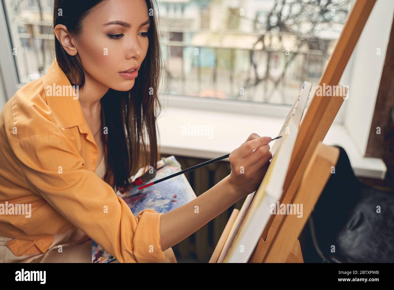 Attraktive junge Frau Bild zu Hause malen Stockfoto