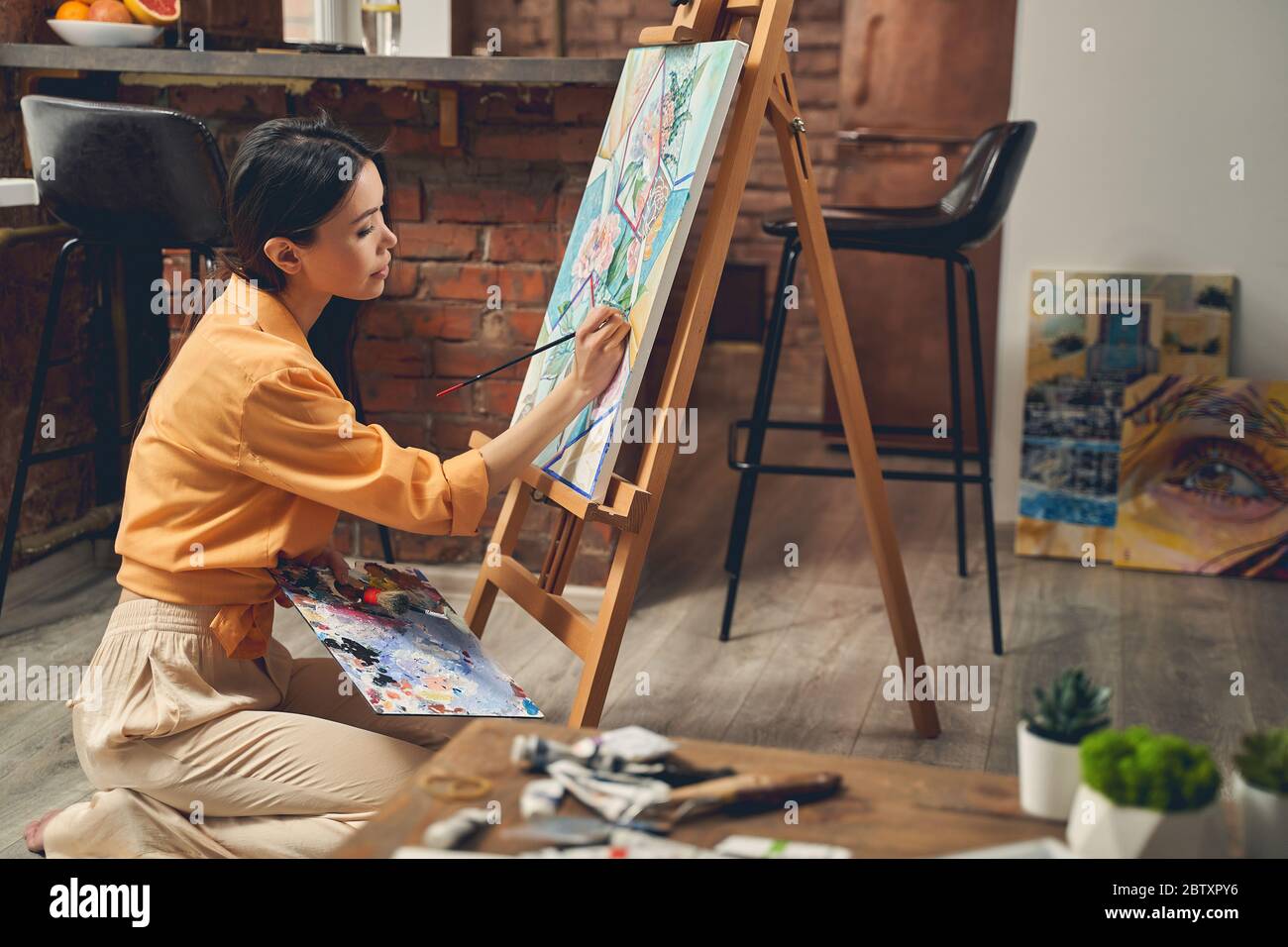 Charmante junge Dame Bild zu Hause malen Stockfoto