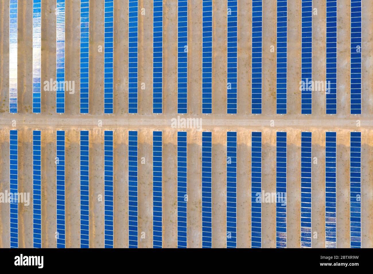Vertikale Luftaufnahme eines Photovoltaik-Solarpaneels, der nachhaltige erneuerbare Energie in einem Wüstenkraftwerk produziert. Stockfoto