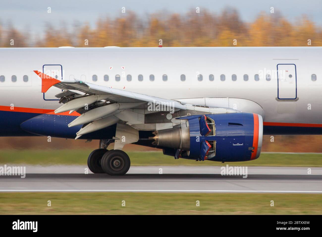 Nahaufnahme der Bremse eines schmalkörper Flugzeugmotors nach der Landung mit geöffneter Schubumkehrklappe, Seitenansicht. Rückstoß des Flugzeugmotors. Stockfoto