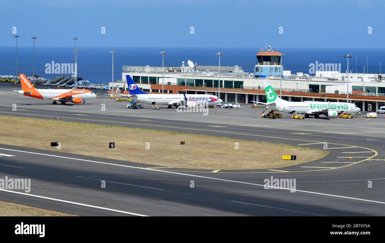 Ein Foto mit der Sicht auf den Flughafen Funchal, komplett mit drei Flugzeugen verschiedener Billigfluggesellschaften Stockfoto