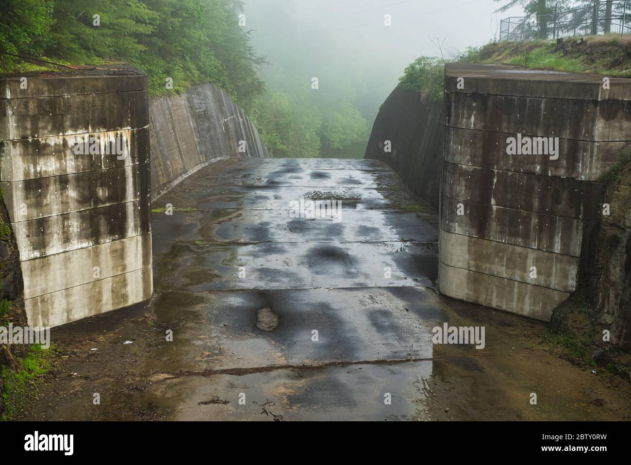 Ein Damm verschüttete an einem nebligen Morgen Stockfoto