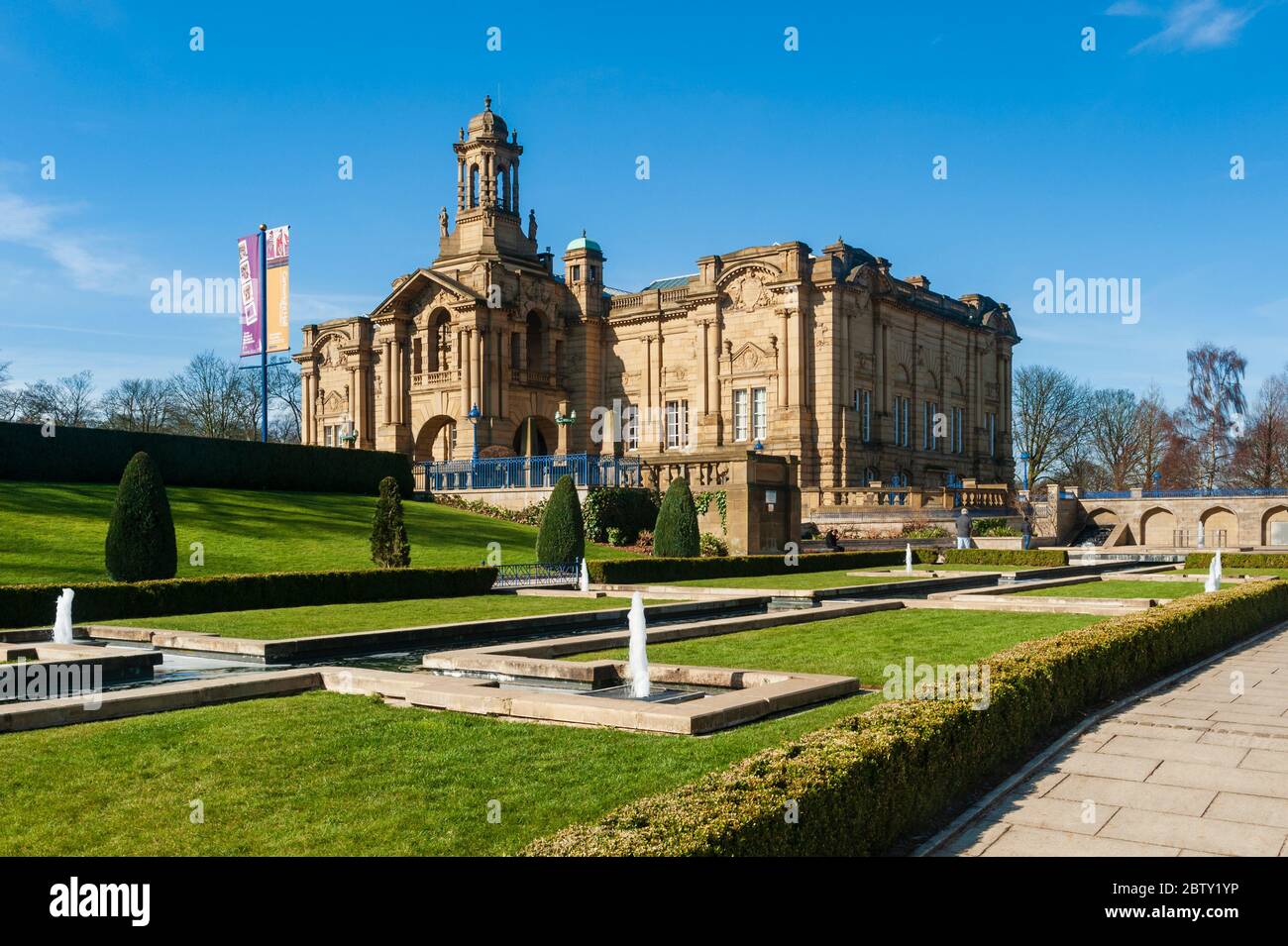 Außenansicht der Stadtkunstgalerie der sonnendurchfluteten Cartwright Hall (großes historisches Museumsgebäude) & Brunnen im Mughal-Wassergarten - Lister Park, Bradford, England Stockfoto