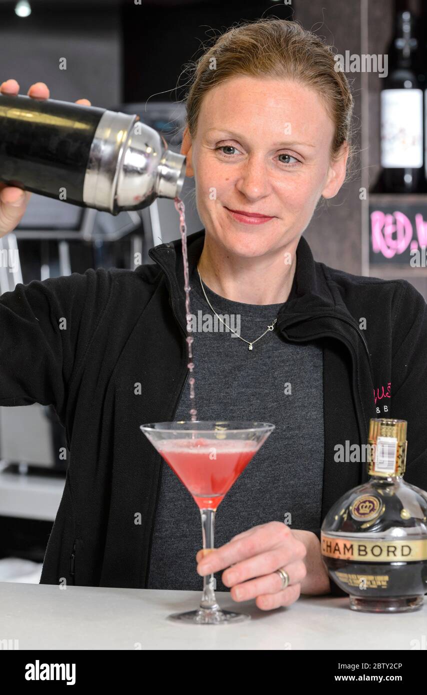 Ein Barkeeper in Coventry, England, gießt einen klassischen rosafarbenen Cocktail Stockfoto