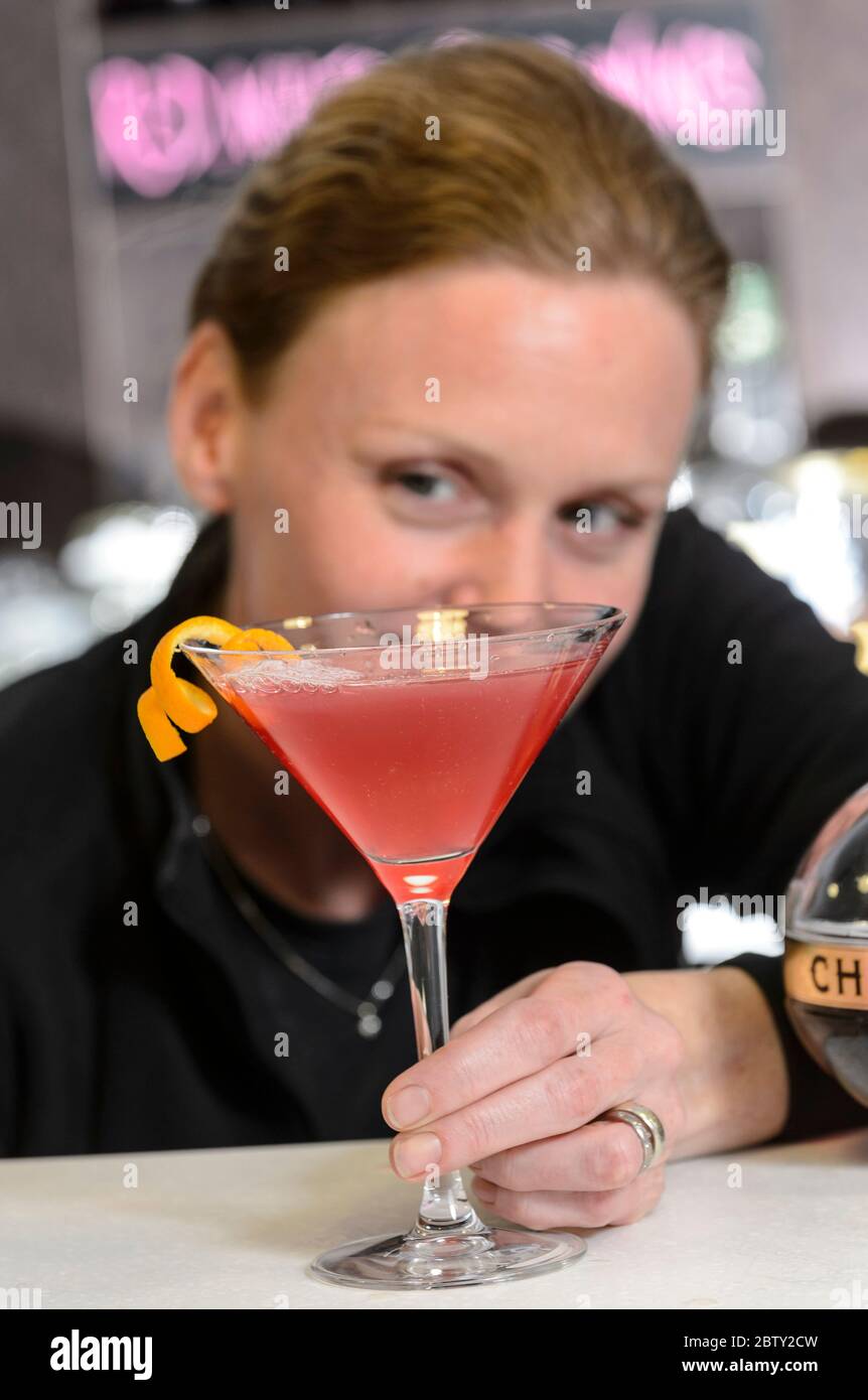 Ein Barkeeper in Coventry, England, gießt einen klassischen rosafarbenen Cocktail Stockfoto