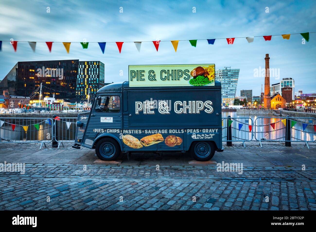 Ein Pie & Chips-Imbißbus am Albert Dock am Ufer des Flusses Mersey während der Abenddämmerung (blaue Stunde), Liverpool, Merseyside, England, Stockfoto