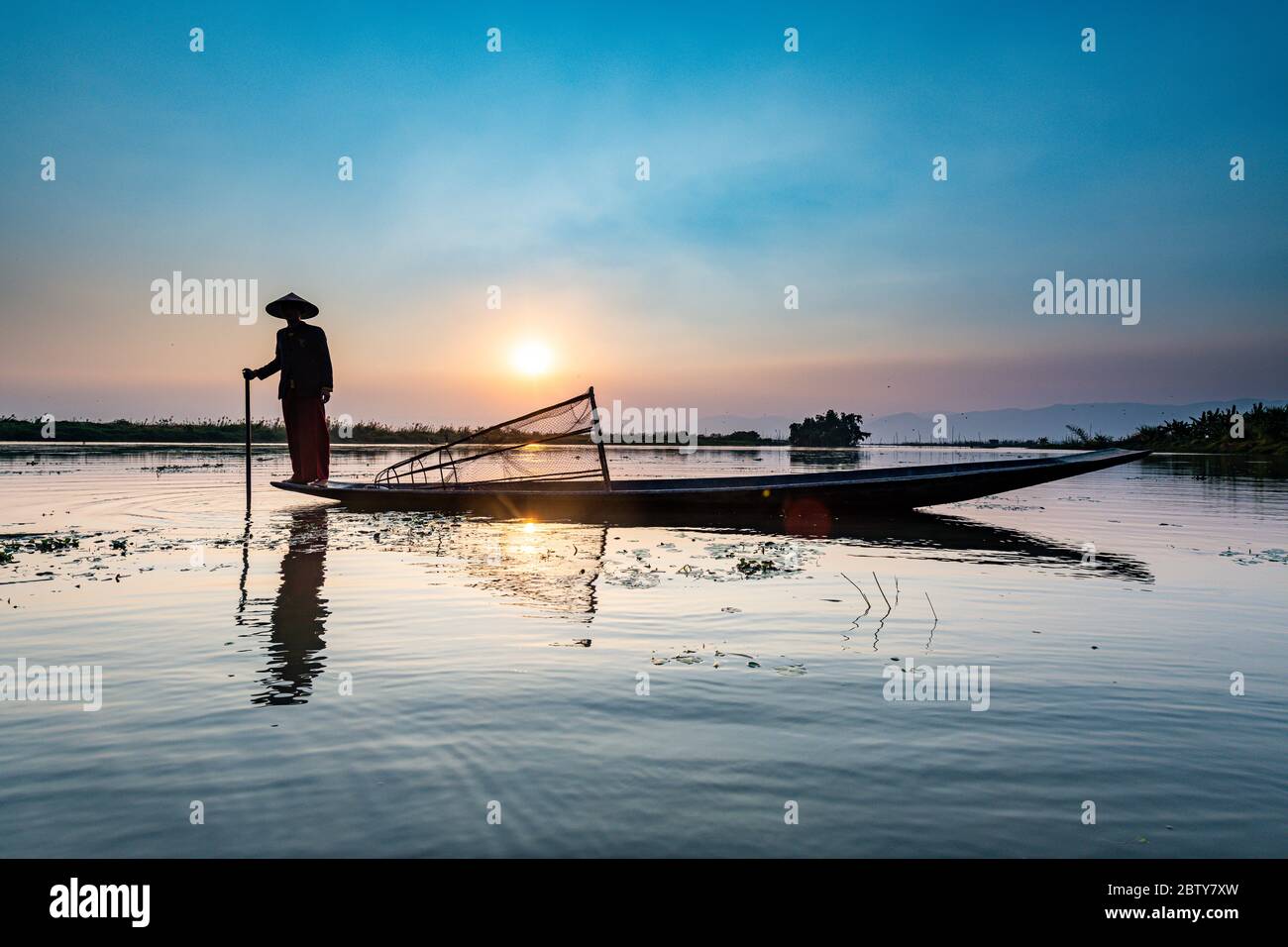 Fischer am Inle See mit traditionellem Intha konischen Netz bei Sonnenuntergang, Fischernetz, Beinruderstil, Intha Menschen, Inle See, Shan Staat, Myanmar (Burm Stockfoto