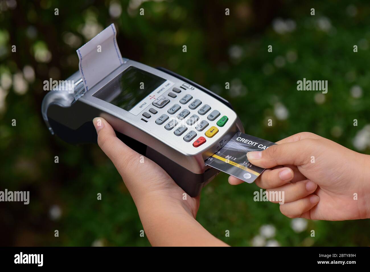 Kreditkarten-Zahlung Konzept. Nahaufnahme Hand einfügen Kreditkarte Mock up mit leeren Karte mit einer Karte Swipe Maschine Stockfoto