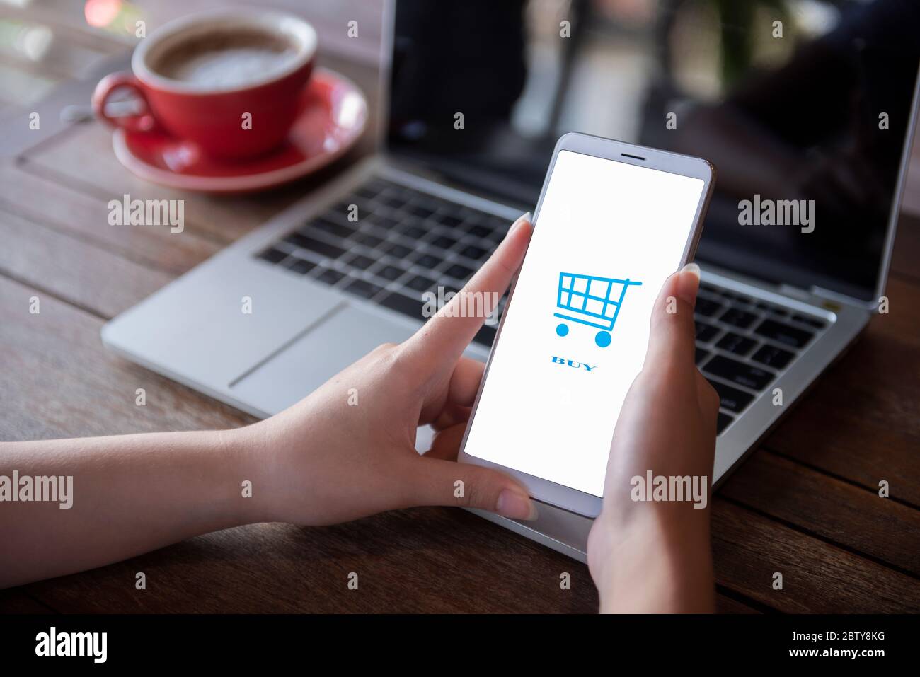 Die Hände der jungen Frau drücken auf das Telefon. Online kaufen Frauen nutzen Computer, Smartphones und Laptops, um online einzukaufen Stockfoto