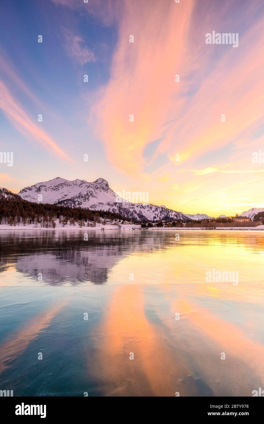 Farben des Sonnenuntergangs spiegeln sich auf der eisigen Oberfläche des Sils-Sees, Engadiner Tal, Graubünden, Schweiz, Europa Stockfoto