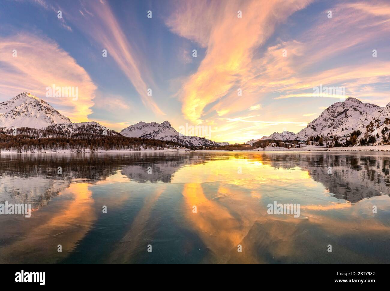 Farben des Sonnenuntergangs spiegeln sich auf der eisigen Oberfläche des Sils-Sees, Engadiner Tal, Graubünden, Schweiz, Europa Stockfoto