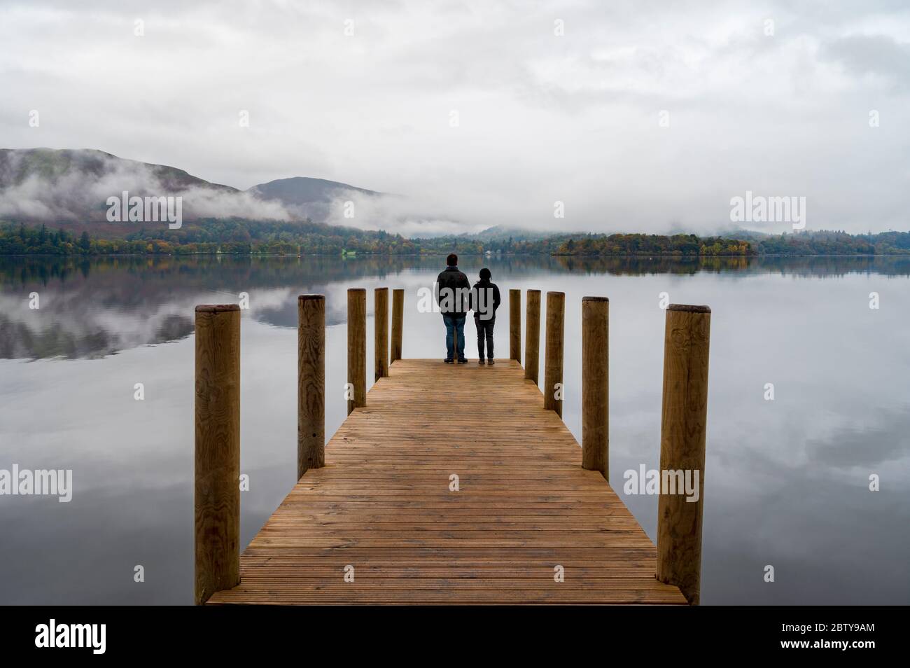 Ein Paar steht auf Ashness Pier Landing Jetty, Derwentwater, Keswick, Lake District National Park, UNESCO-Weltkulturerbe, Cumbria, England, Uni Stockfoto
