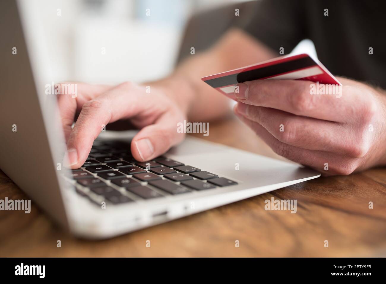 Online-Shopping-Konzept, Person Eingabe Zahlungsinformationen auf Laptop-Computer mit Debit-oder Kreditkarte in anderer Hand Stockfoto